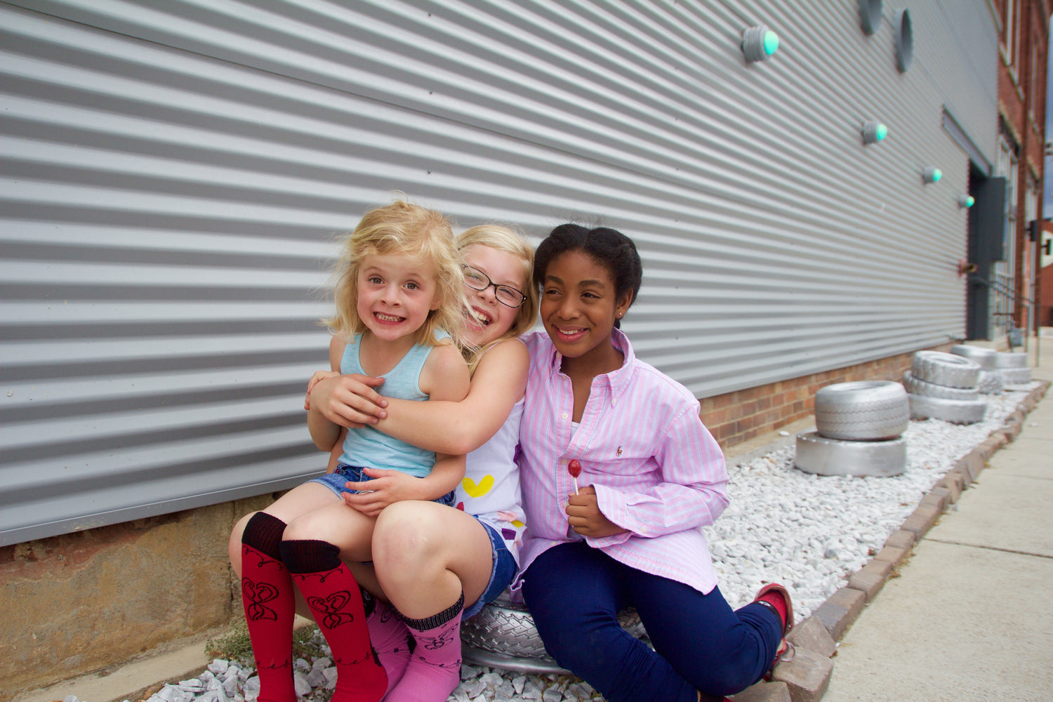 Children sitting in on rocks in Avondale Birmingham, Alabama modeling SoleMate Sox