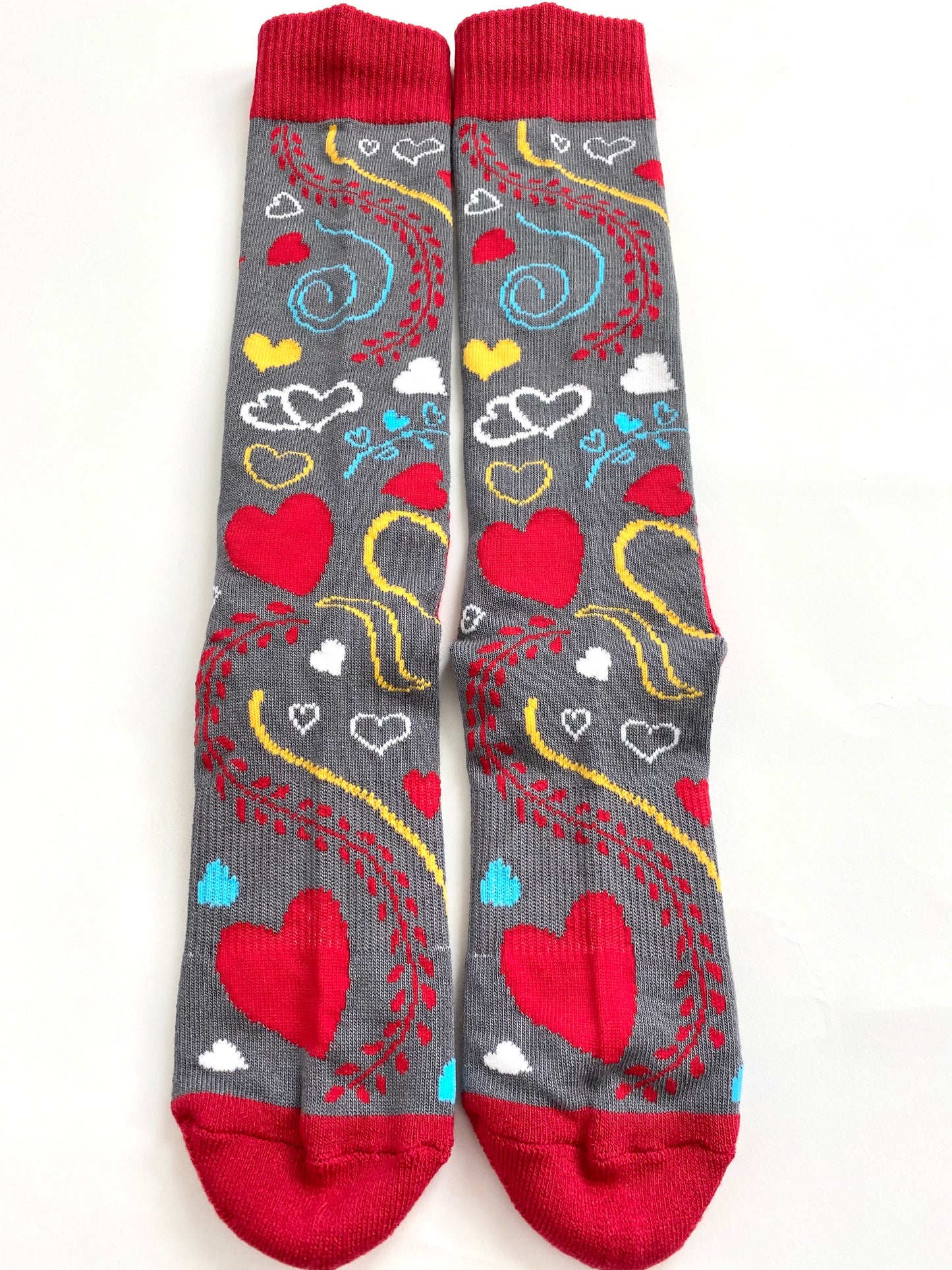 SoleMate Sox Heal Your Heart Bamboo Socks are decorated with red, yellow, teal, and white hearts with squiggle lines.  They are magnetic and stay together in the laundry. Our socks are never lost or missing.